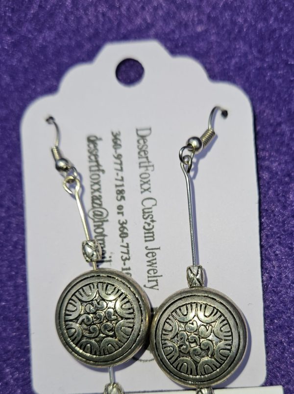 Approximately 2 1/8 inch round silver findings with designs and silver beads with stainless steel ear wires.