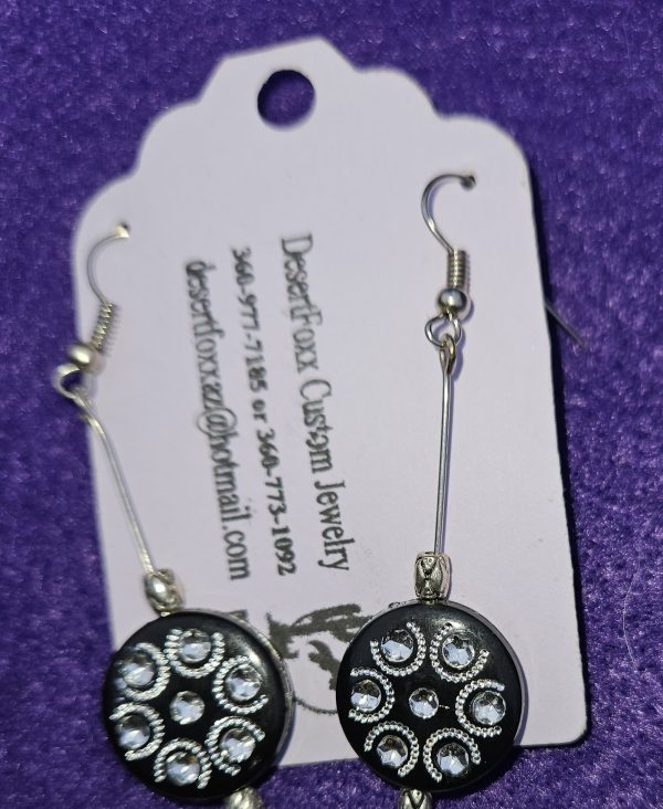 Approximately 2⅛ inches black round disk with silver design finished with four silver findings.