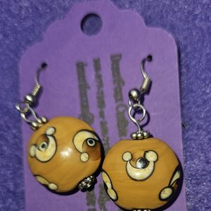 Approximately 1½ inch round brown beads with designs, silver findings, and stainless steel ear wires.