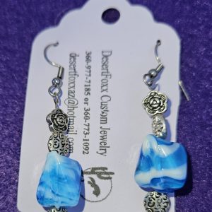 Approximately 2 inch in length with blue shaded beads with white encrusted design with silver findings stainless steel ear wires.