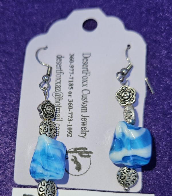 Approximately 2 inch in length with blue shaded beads with white encrusted design with silver findings stainless steel ear wires.