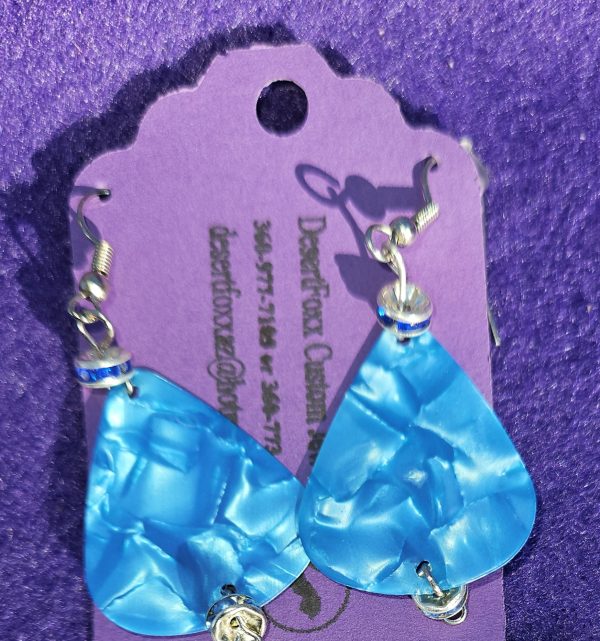 Approximately 2 inches Fluorescent blue guitar pick earrings with silver findings and ear wires.