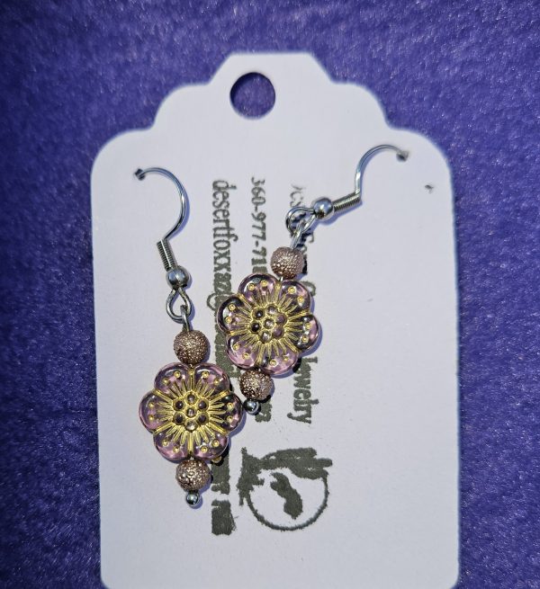 Approximately 1 3/8 inch long. Clear violet beads with gold designs and gold brocade floweret and stainless ear wires.