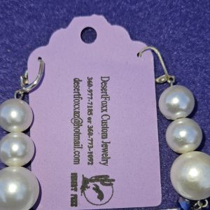 Approximately 2 3/8 inches long. Large simulated pearls, purple beads, and stainless ear wires.