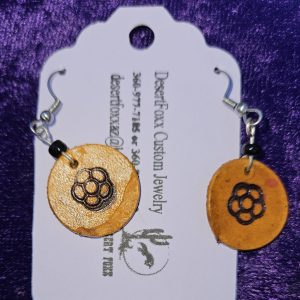 Approximately 1 5/8 inch long. Branded leather disk with black beads.