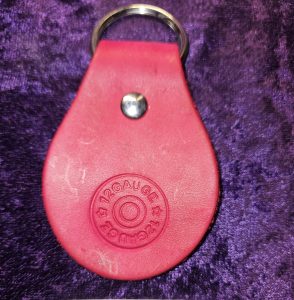 Leather dyed red with shot gun stamp approximately 3 inches long by 2 inches wide.