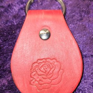 Leather dyed red with rose stamp approximately 3 inches long by 2 inches wide.