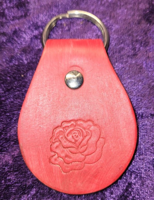 Leather dyed red with rose stamp approximately 3 inches long by 2 inches wide.