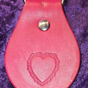 Leather dyed red with heart stamp approximately 3 inches long by 2 inches wide.