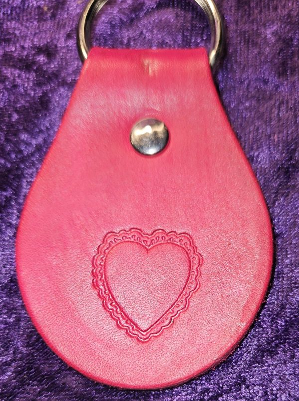 Leather dyed red with heart stamp approximately 3 inches long by 2 inches wide.