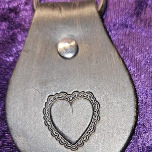 Leather dyed black with heart stamp approximately 3 inches long by 2 inches wide.