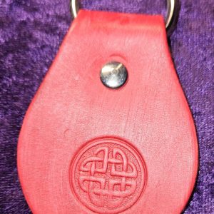 Leather dyed read with Celtic design stamp approximately 3 inches long by 2 inches wide.