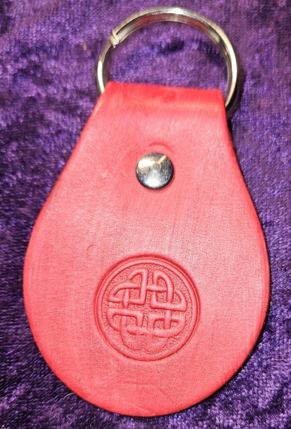 Leather dyed read with Celtic design stamp approximately 3 inches long by 2 inches wide.