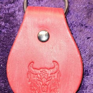 Leather dyed red with native motif stamp approximately 3 inches long by 2 inches wide.