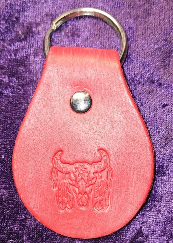 Leather dyed red with native motif stamp approximately 3 inches long by 2 inches wide.