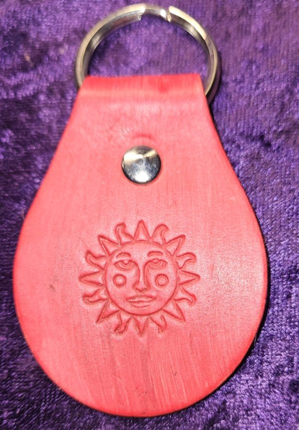 Leather dyed red with sun faced stamp approximately 3 inches long by 2 inches wide.