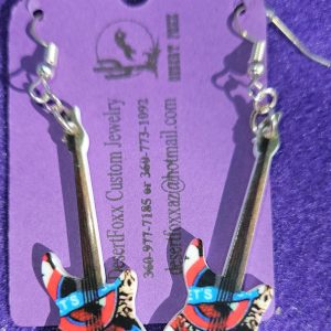 Approx. 2 5/8 inches Pastic guitar with white base and red and black design with silver ear wires. 21.99