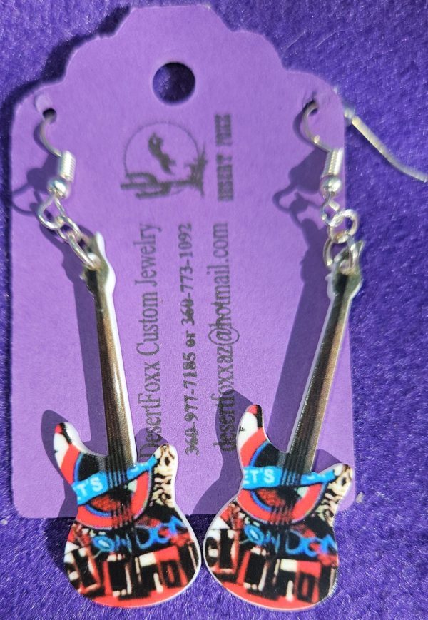 Approx. 2 5/8 inches Pastic guitar with white base and red and black design with silver ear wires. 21.99