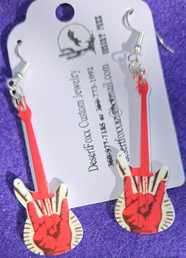 Approx. 2 5/8 inches, Plastic guitar with white base with red and black design with silver ear wires. 21.99