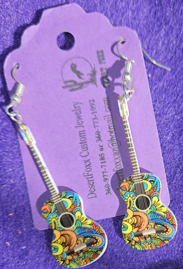 Approx 2 5/8 inches, Plastic guitar with multi colored design with silver ear wires. 21.99
