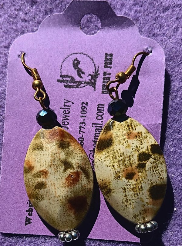Approx. 2 inches, Marquise shaped bead with black/tan/green design with silver findings and gold earwires and black beads.